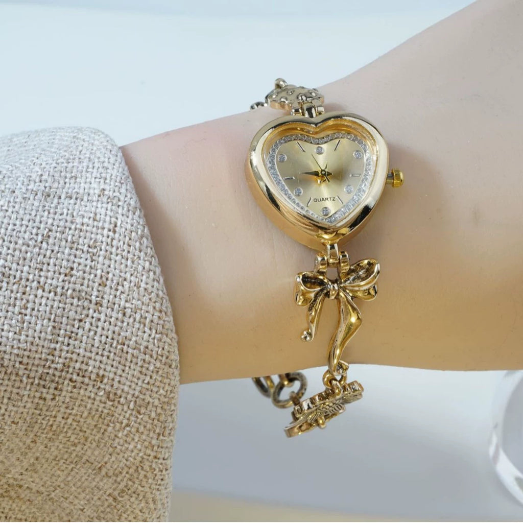 Heart Case Bracelet Watch — Gold-Tone, Crystal Bezel, Champagne Dial & Bow Charm Chain, Women