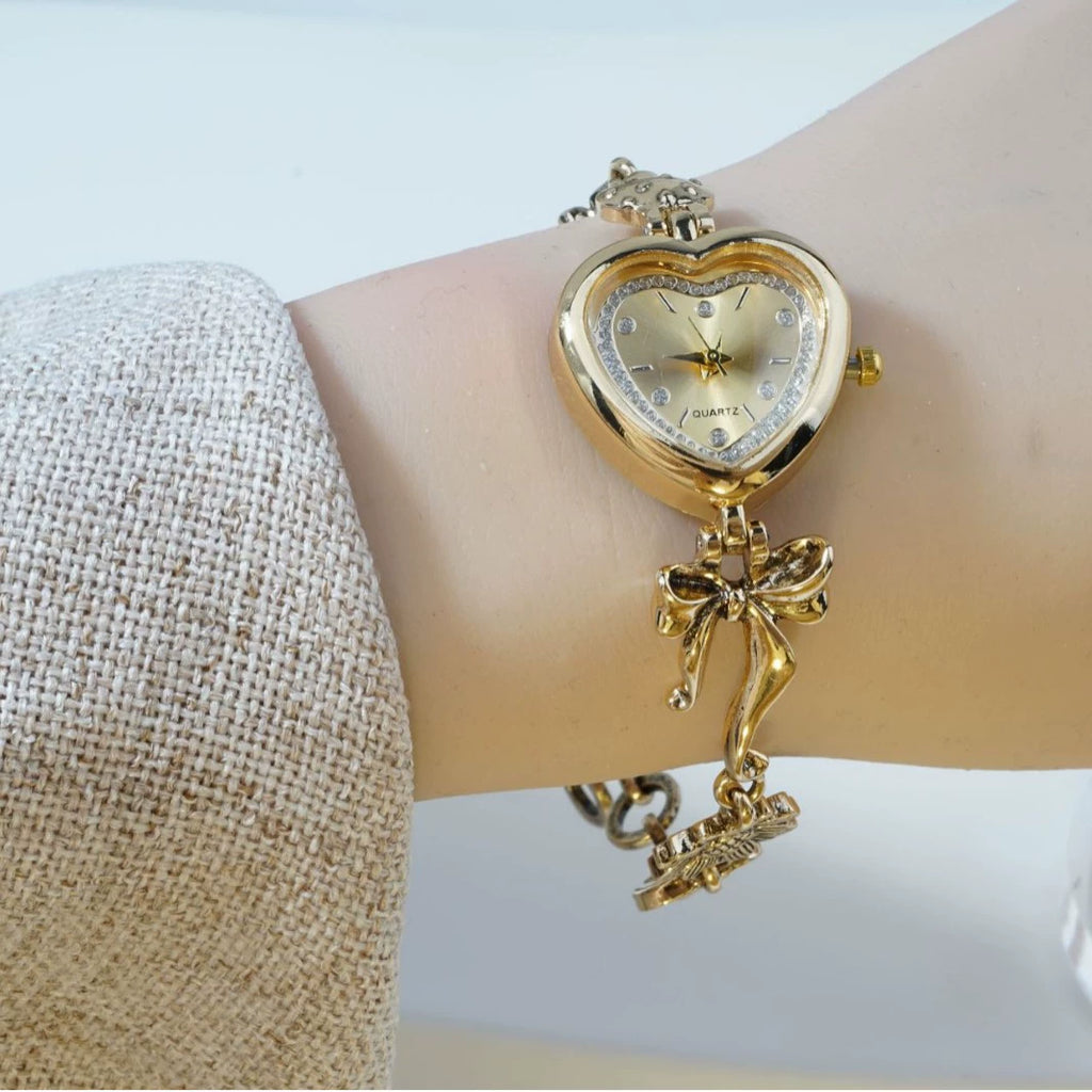 Heart Case Bracelet Watch — Gold-Tone, Crystal Bezel, Champagne Dial & Bow Charm Chain, Women