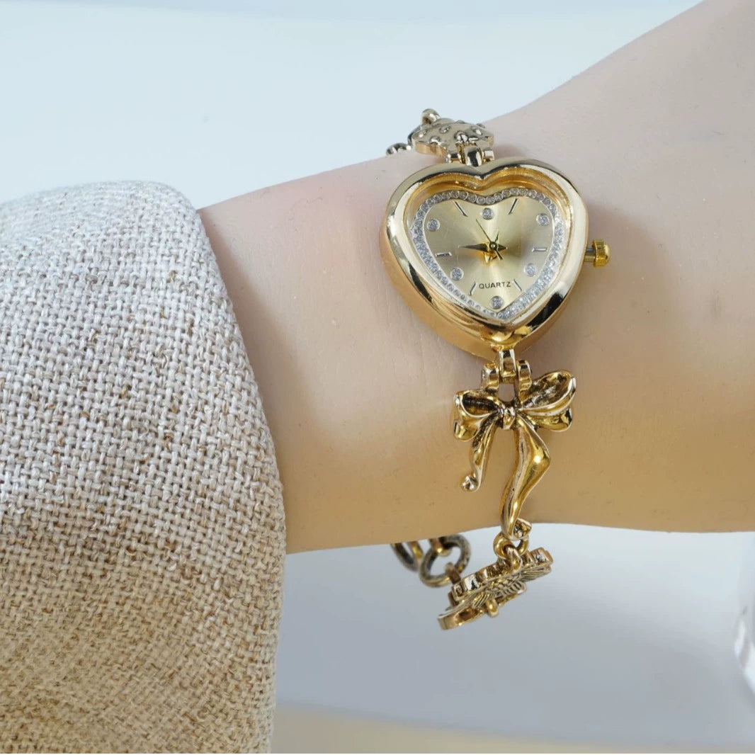 Heart Case Bracelet Watch — Gold-Tone, Crystal Bezel, Champagne Dial & Bow Charm Chain, Women